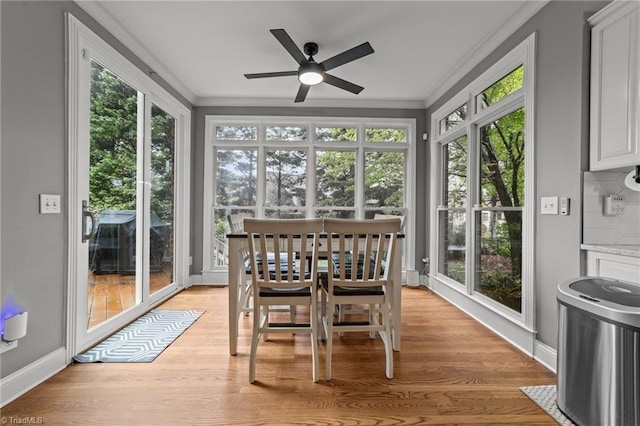 sunroom with wood finished floors, baseboards, and a healthy amount of sunlight