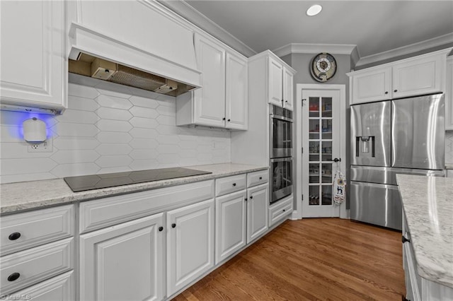 kitchen with custom range hood, tasteful backsplash, crown molding, white cabinets, and stainless steel appliances