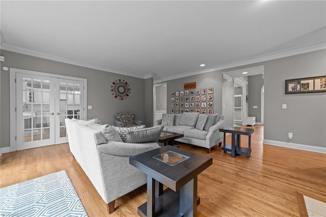 living room featuring ornamental molding, french doors, and light wood-style flooring