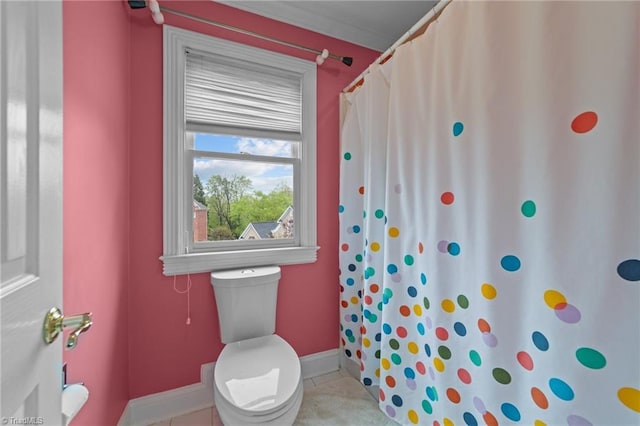 bathroom featuring toilet, baseboards, tile patterned flooring, and a shower with curtain