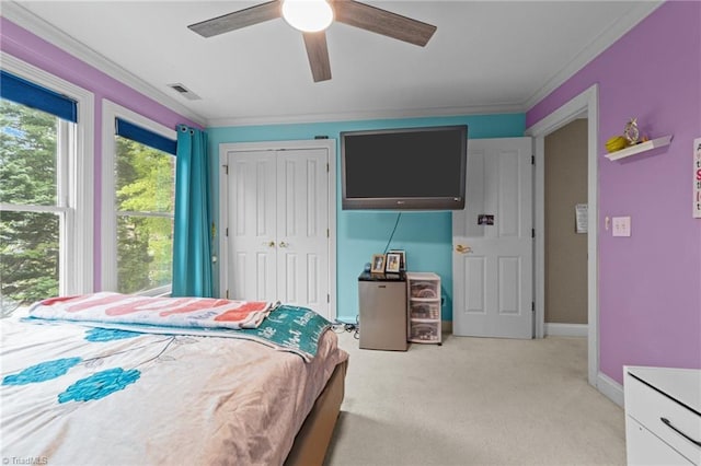 bedroom featuring light carpet, visible vents, crown molding, and ceiling fan