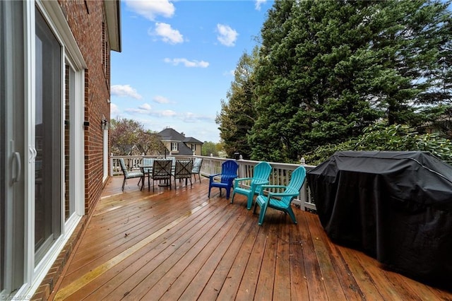wooden deck with grilling area and outdoor dining space