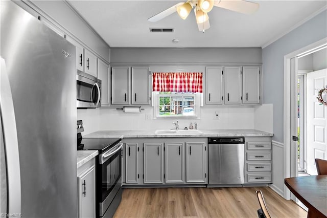 143 Chrisfield Cir, Winston-Salem, NC 27104 - kitchen featuring stainless steel appliances, a sink, a ceiling fan, light wood-style flooring, and gray cabinets