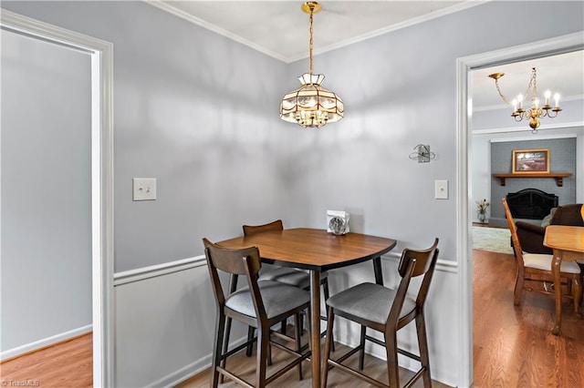 143 Chrisfield Cir, Winston-Salem, NC 27104 - dining space with a chandelier, crown molding, wood finished floors, and a fireplace