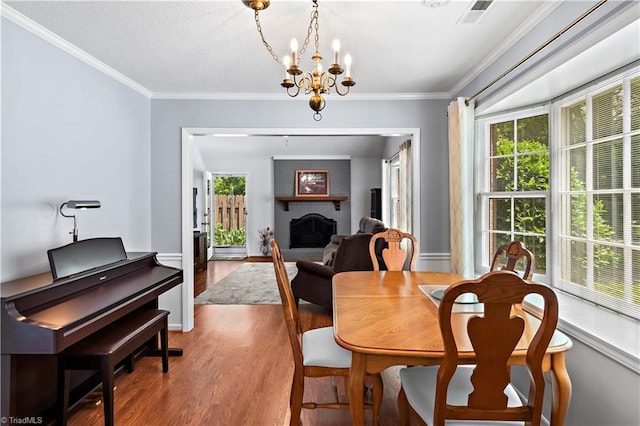 143 Chrisfield Cir, Winston-Salem, NC 27104 - dining space with wood finished floors, a chandelier, a brick fireplace, ornamental molding, and baseboards
