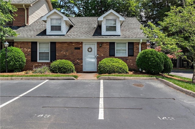 143 Chrisfield Cir, Winston-Salem, NC 27104 - cape cod-style house featuring brick siding, uncovered parking, and roof with shingles