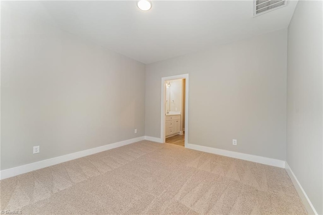 spare room featuring light colored carpet