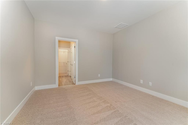 unfurnished room featuring light colored carpet