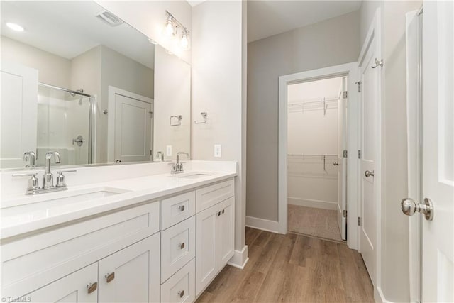 bathroom with vanity, hardwood / wood-style floors, and walk in shower