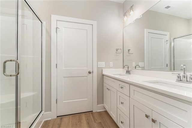 bathroom with wood-type flooring, vanity, and walk in shower