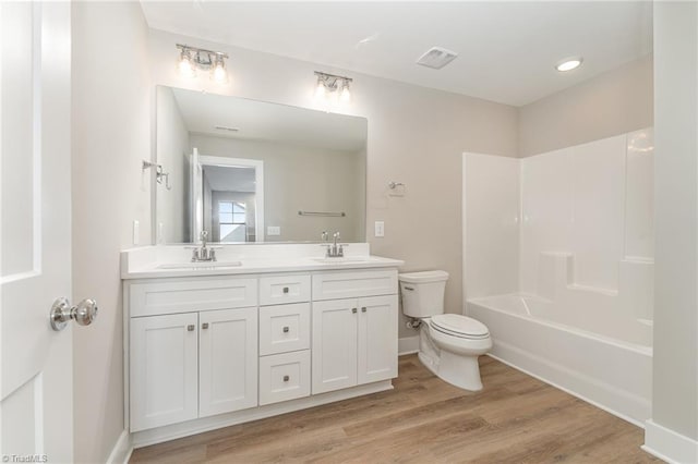 full bathroom featuring hardwood / wood-style flooring, vanity, toilet, and shower / washtub combination