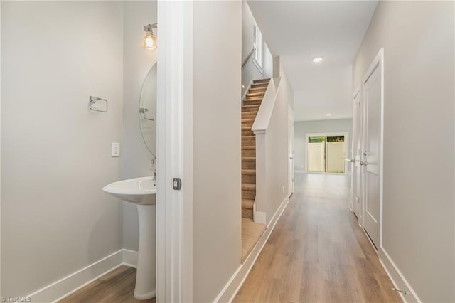 hallway featuring sink and light hardwood / wood-style floors