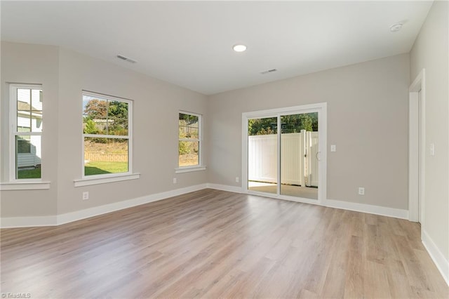 spare room with a wealth of natural light and light hardwood / wood-style floors