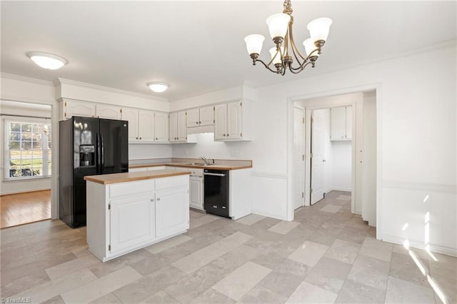 kitchen with a center island, a chandelier, decorative light fixtures, white cabinets, and black appliances