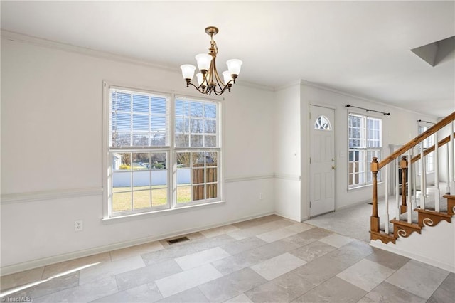 foyer featuring crown molding and an inviting chandelier