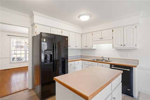 kitchen featuring ornamental molding, sink, black appliances, white cabinets, and a kitchen island