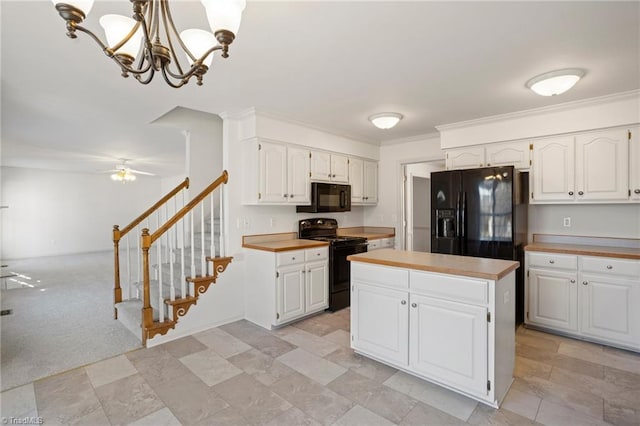 kitchen featuring white cabinetry, a center island, black appliances, and decorative light fixtures