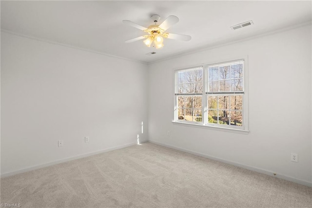 spare room with ceiling fan, ornamental molding, and light carpet