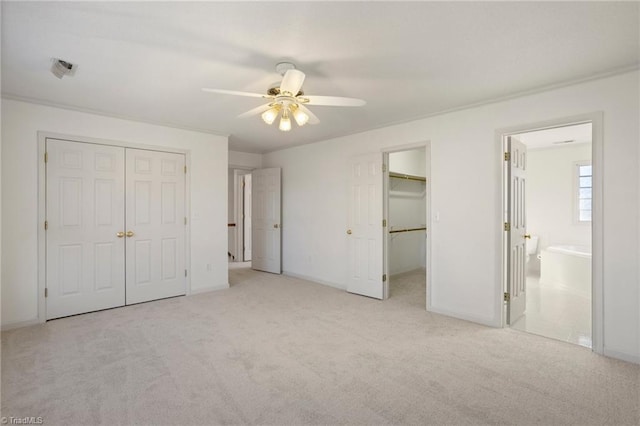 unfurnished bedroom with light carpet, ensuite bath, and ceiling fan