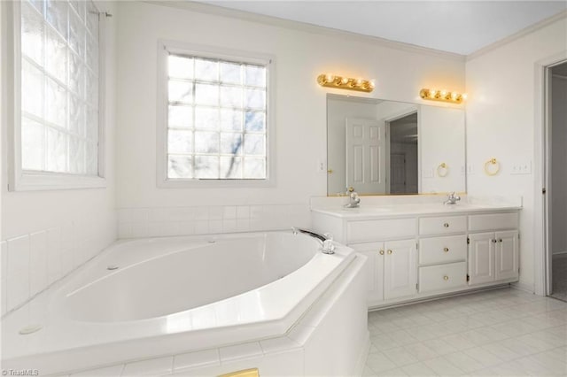 bathroom featuring vanity, ornamental molding, and a bath