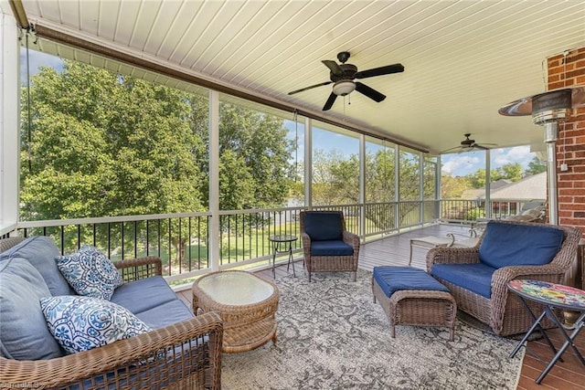 sunroom featuring a ceiling fan and an outdoor living space