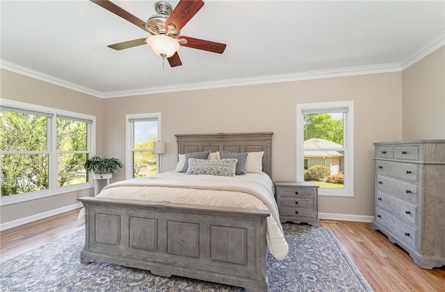 bedroom with crown molding, baseboards, light wood-type flooring, and a ceiling fan