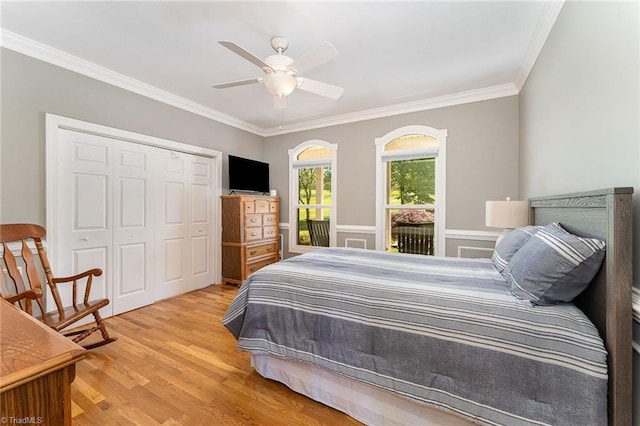 bedroom with crown molding, light wood-style flooring, a closet, and a ceiling fan