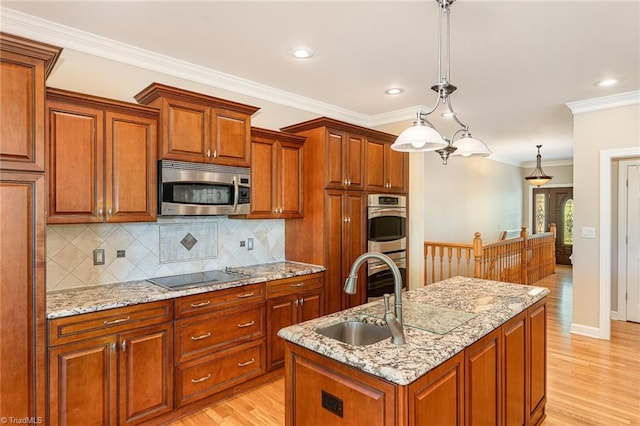 kitchen featuring stainless steel appliances, a sink, light wood-type flooring, decorative backsplash, and ornamental molding