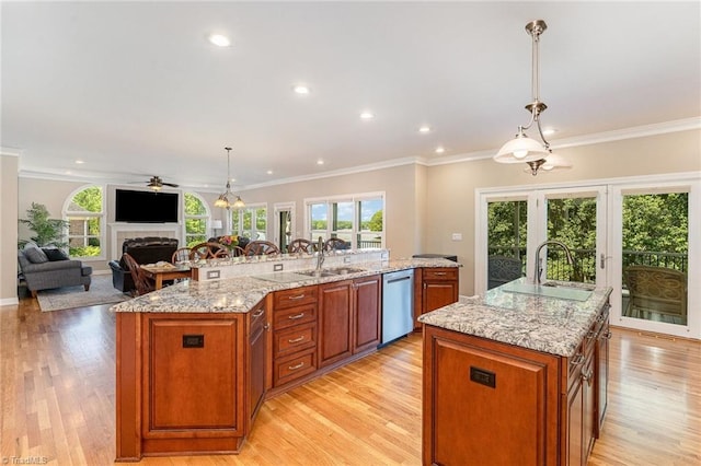 kitchen with a spacious island, dishwasher, a fireplace, plenty of natural light, and crown molding