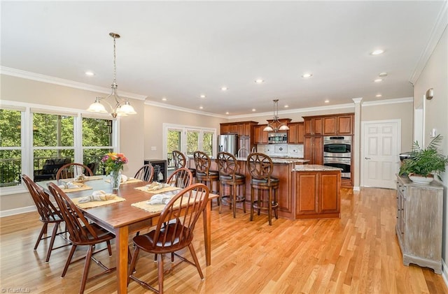 dining area featuring light wood-type flooring, recessed lighting, ornamental molding, and a chandelier