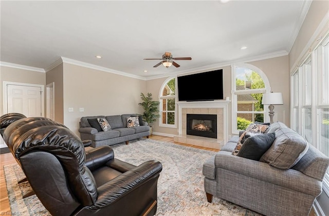living room with wood finished floors, plenty of natural light, ceiling fan, recessed lighting, and crown molding