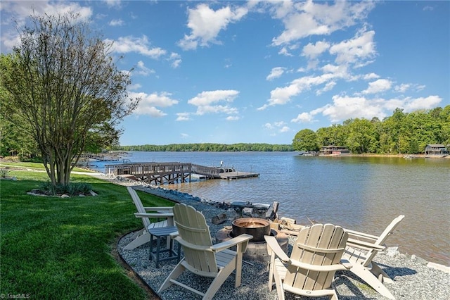 dock featuring an outdoor fire pit, a water view, and a lawn