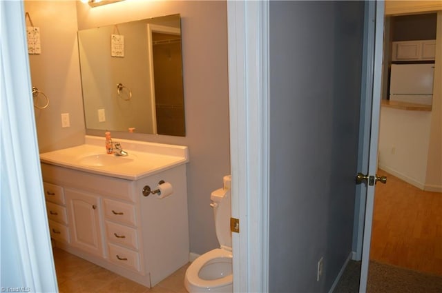 bathroom with vanity, hardwood / wood-style flooring, and toilet