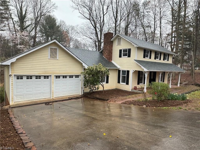 view of front of home featuring a garage, driveway, roof with shingles, and a chimney