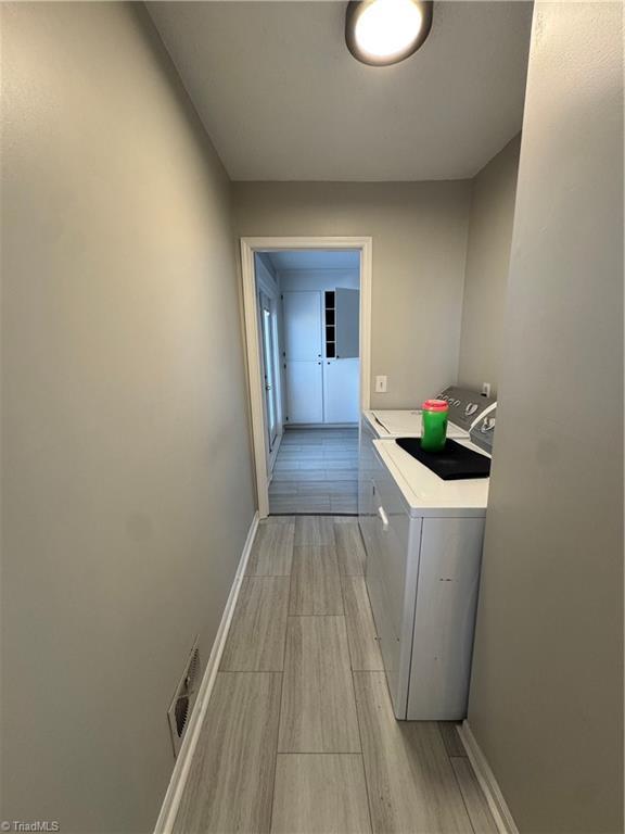 laundry area with baseboards, laundry area, visible vents, and washer and dryer