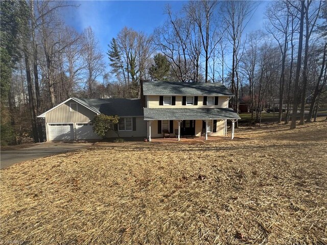 view of front facade with a porch, an attached garage, and aphalt driveway