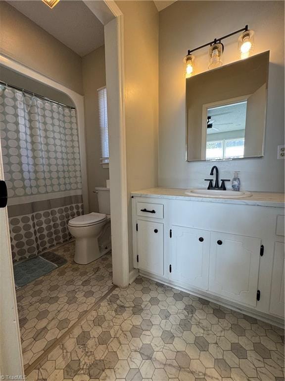 full bath featuring a shower with curtain, vanity, and toilet