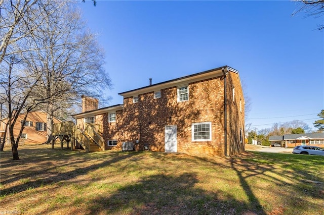 rear view of property with a yard and a wooden deck