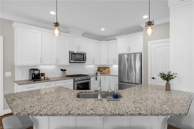 kitchen with sink, white cabinetry, hanging light fixtures, stainless steel appliances, and backsplash