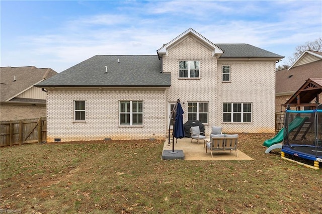 rear view of property with a trampoline, a lawn, a patio, and a playground