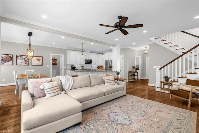 living room with hardwood / wood-style floors, crown molding, sink, and ceiling fan