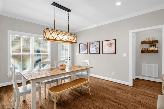 dining room featuring ornamental molding and dark hardwood / wood-style floors