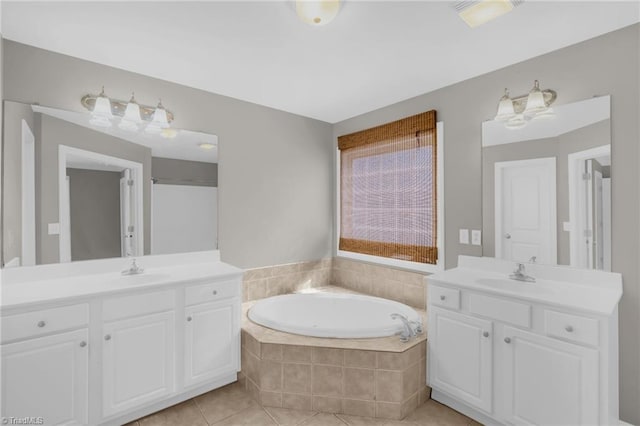 bathroom featuring tile patterned floors, two vanities, a sink, and a bath