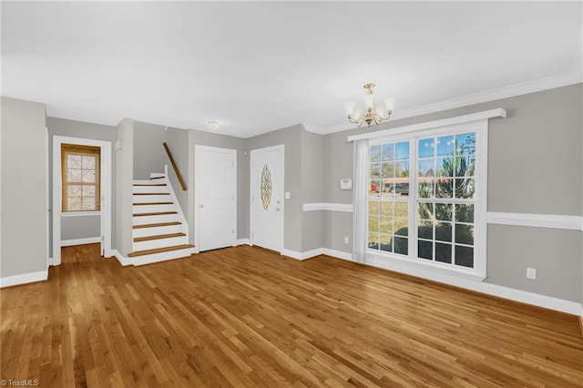 interior space featuring baseboards, wood finished floors, a chandelier, and stairway