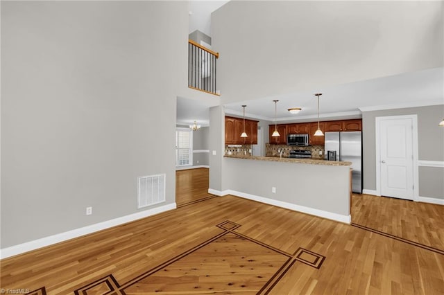unfurnished living room featuring baseboards, visible vents, and light wood-type flooring