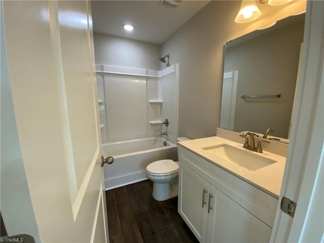 full bath with vanity, shower / washtub combination, wood finished floors, and toilet