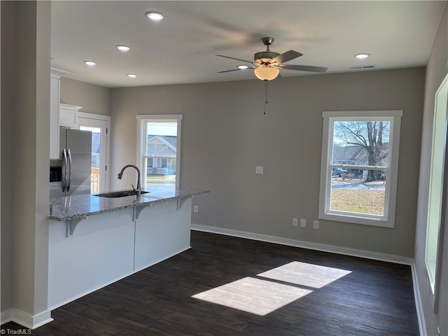 1709 Morning View Dr, Greensboro, NC 27401 - kitchen featuring stainless steel fridge, a sink, a kitchen breakfast bar, a peninsula, and white cabinetry