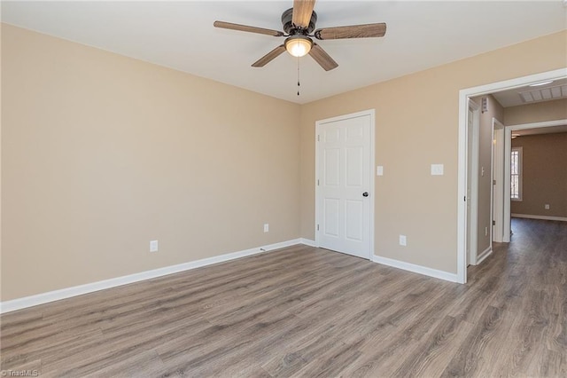 unfurnished room featuring visible vents, ceiling fan, baseboards, and wood finished floors