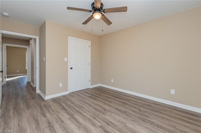 unfurnished bedroom with a ceiling fan, baseboards, and wood finished floors