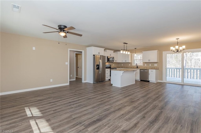 unfurnished living room featuring dark wood-style floors, a sink, visible vents, and baseboards